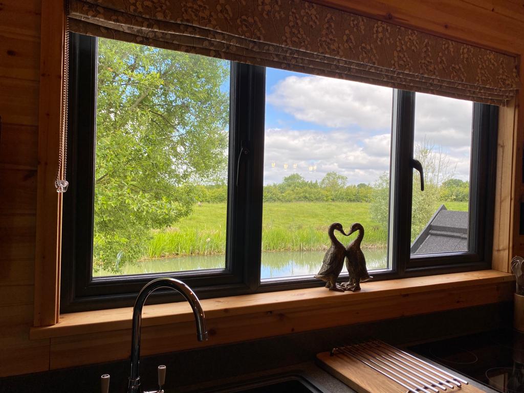 A kitchen window with a view of a river.
