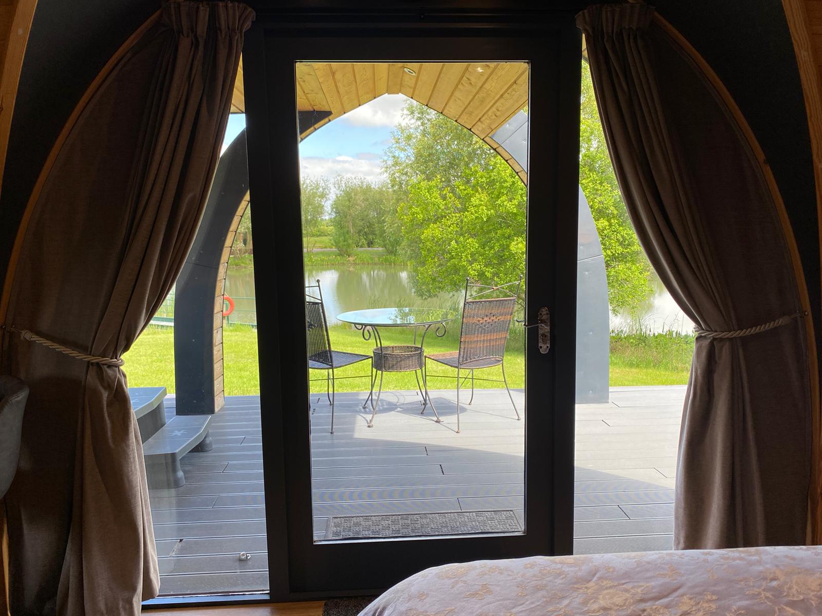 A bedroom with a sliding glass door leading to a patio with a table and chairs.