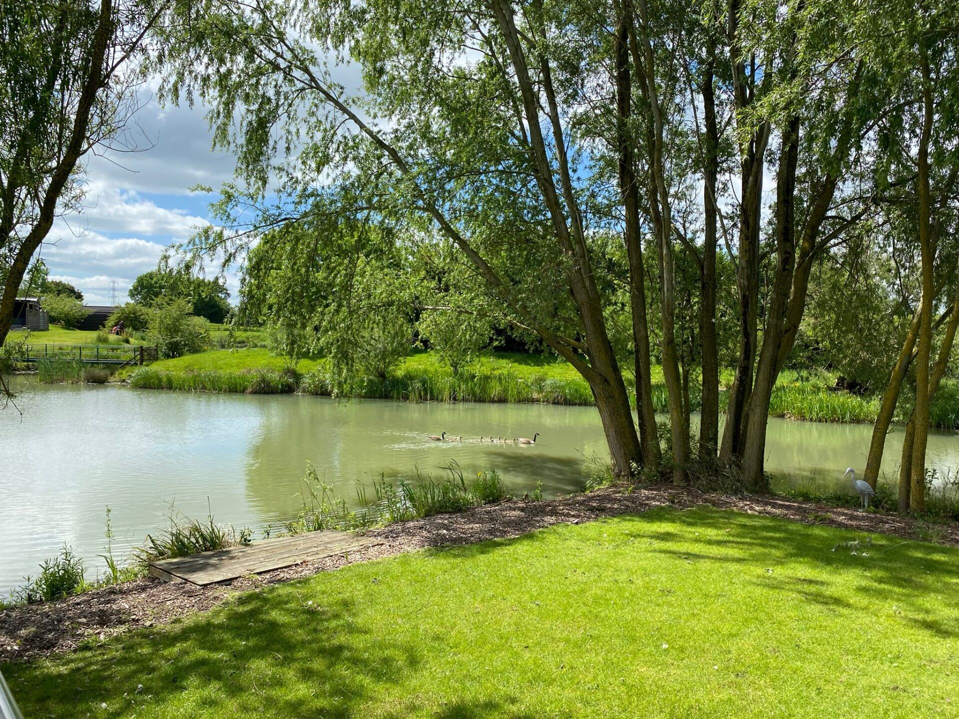 There is a bridge over a body of water in front of a house.