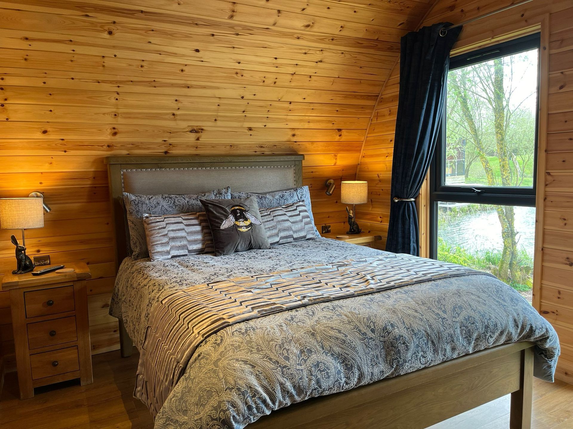 A bedroom in a log cabin with a large bed and a window.
