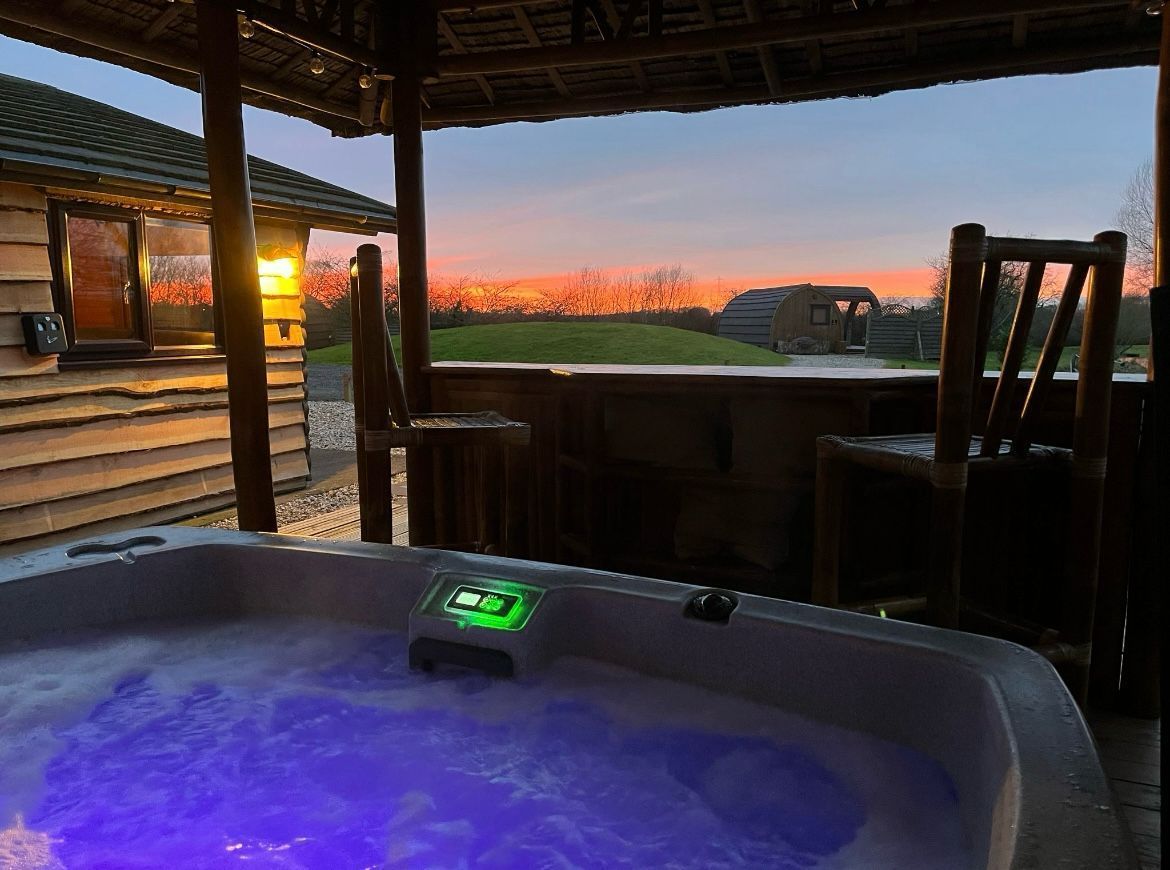 A hot tub is sitting on a wooden deck next to a wooden bar.