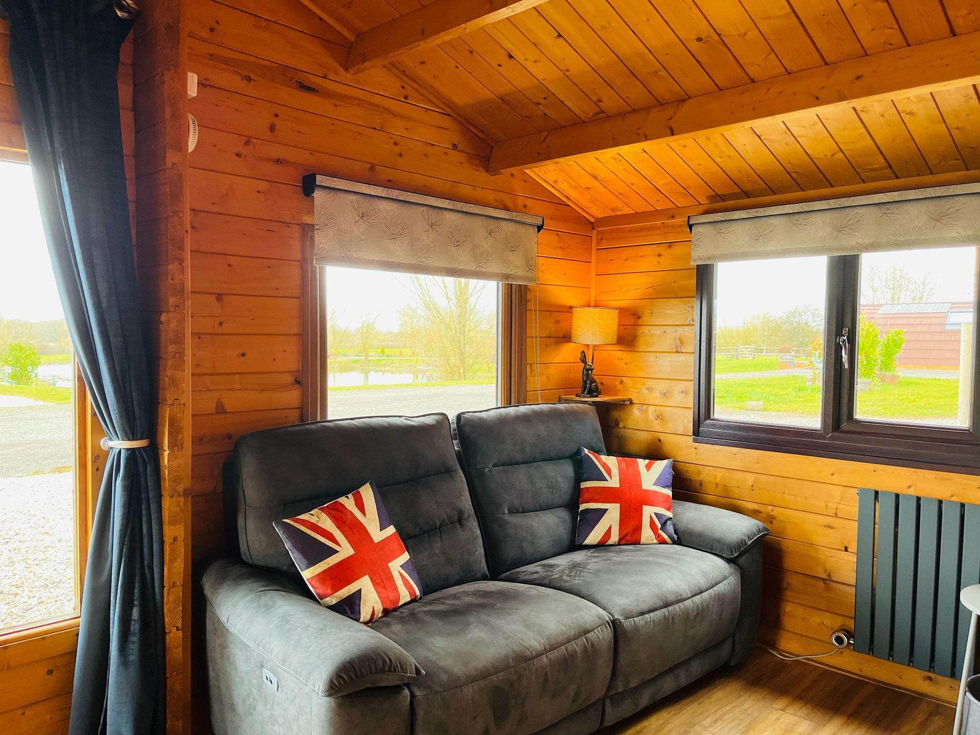 A living room in a log cabin with a couch and a television.
