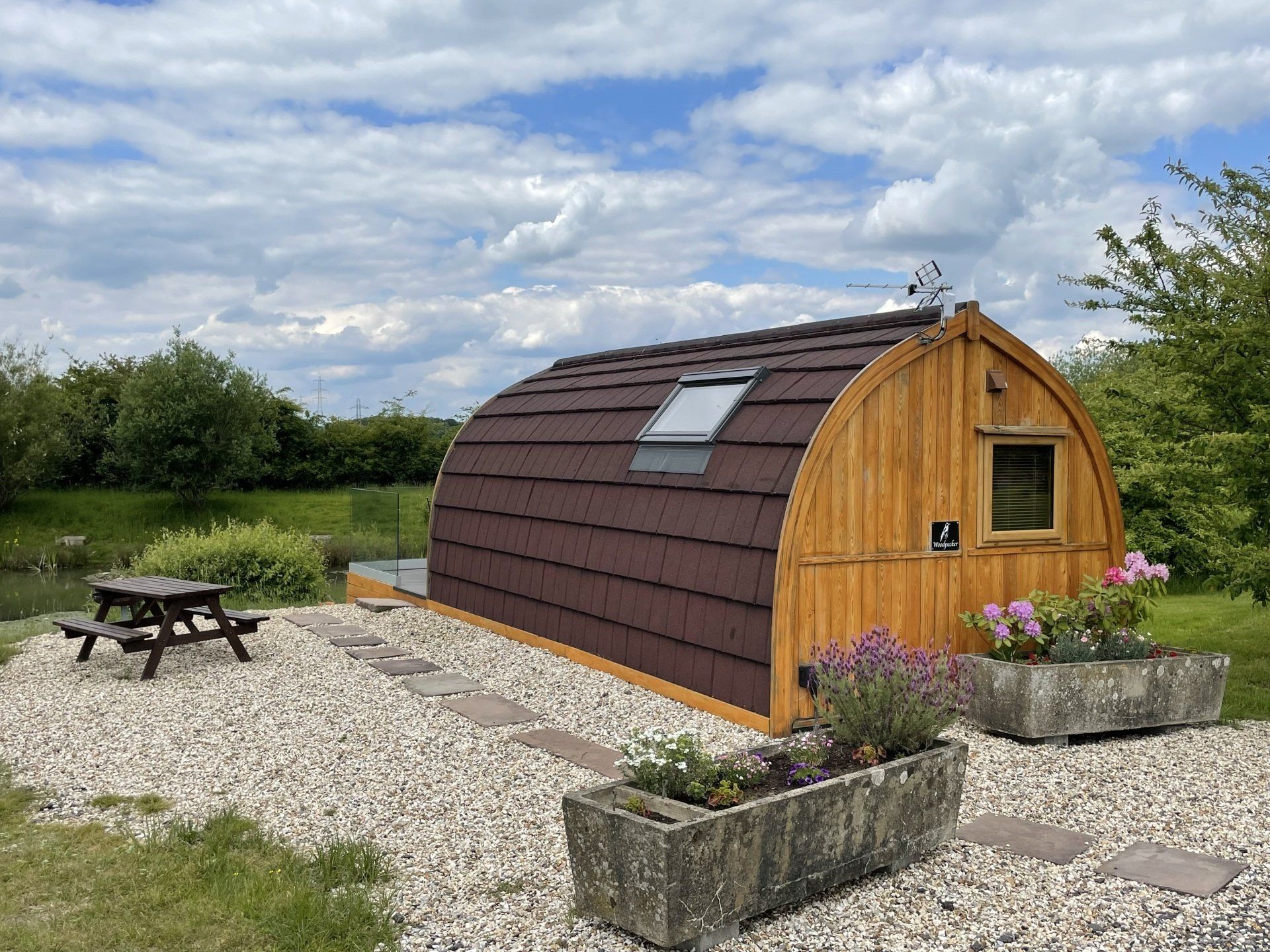 A small wooden house with a picnic table in front of it.