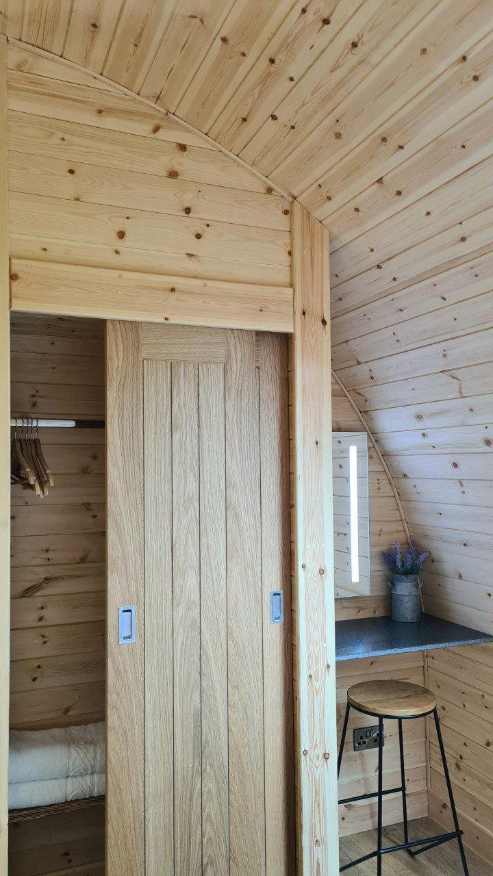A wooden room with a sliding door and a desk.