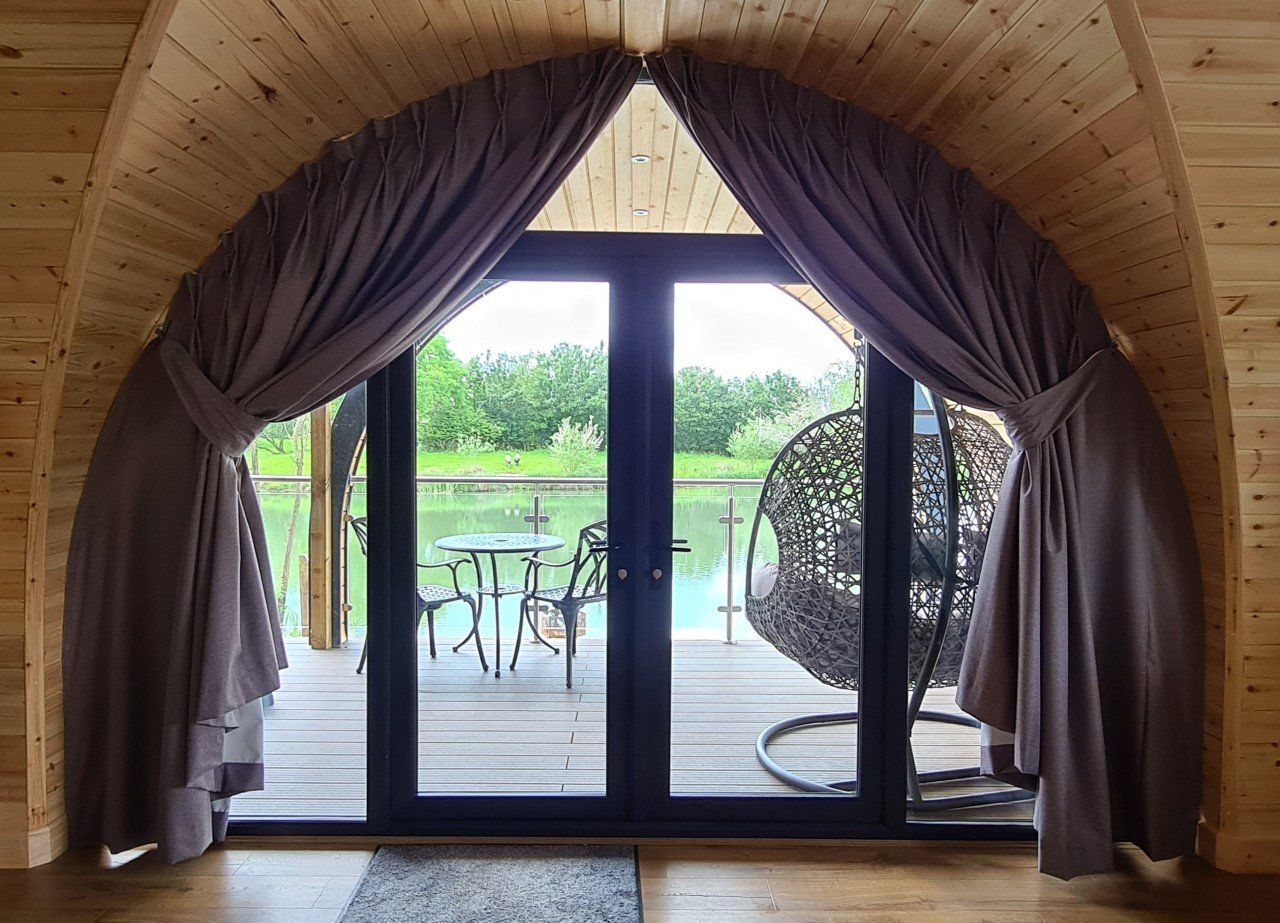 A room with a view of a lake through a large window.