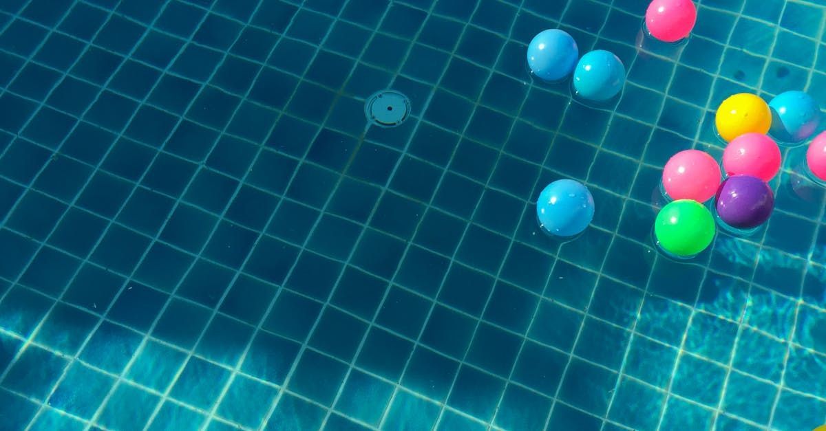 A bunch of colorful balls are floating in a swimming pool.