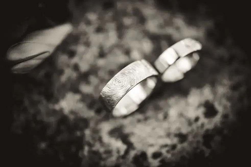 Two silver rings on a dark, textured surface in soft focus