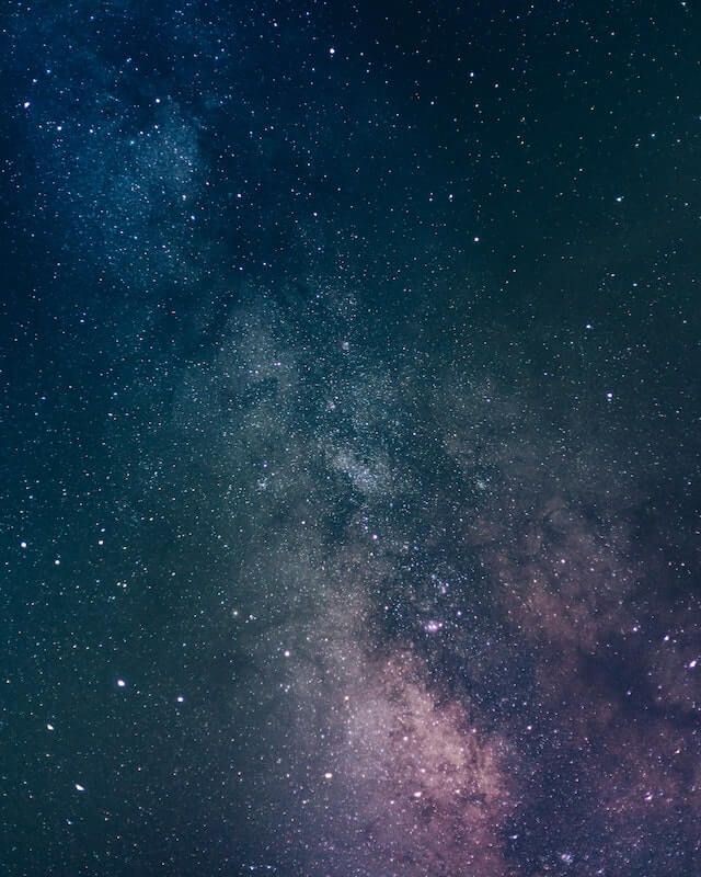 Starry night sky with the Milky Way glowing in blue and pink hues