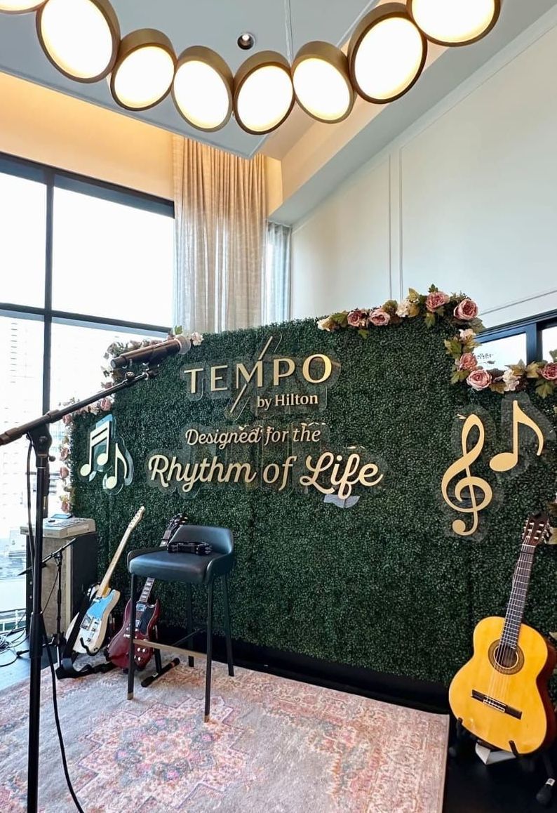 Live music stage with green wall, guitars, microphone, and 
