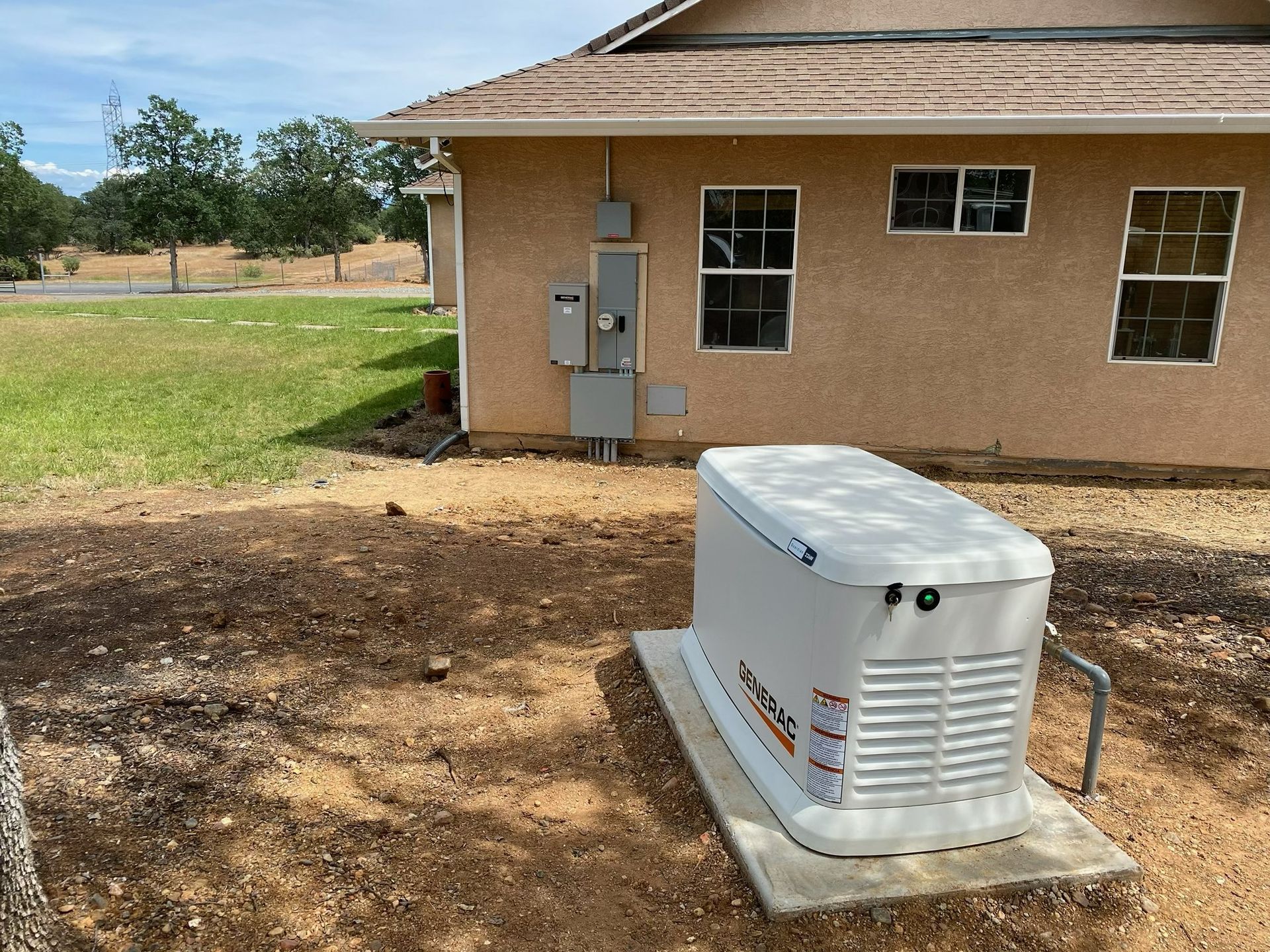 Outdoor generator beside a tan house with electrical meter and grassy yard