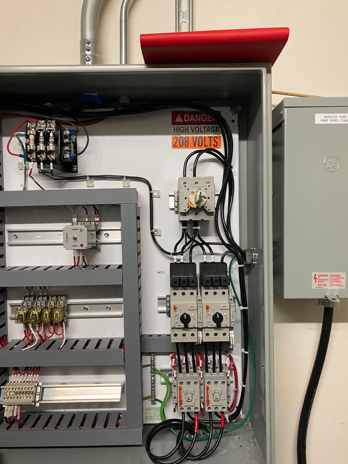 Open electrical control panel with wiring, breakers, and a 240 volts warning label.