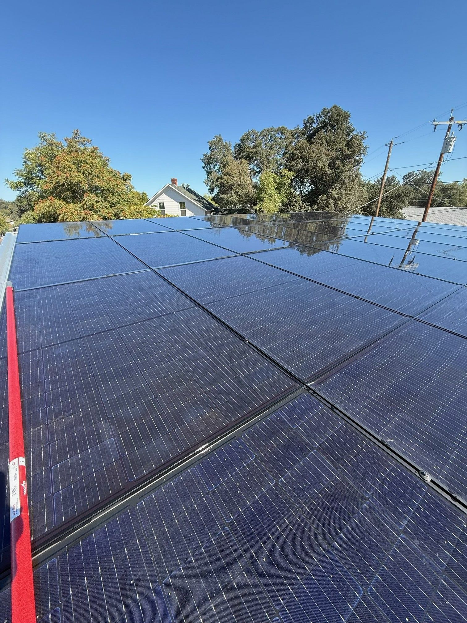 Blue solar panels on a roof under a clear sky