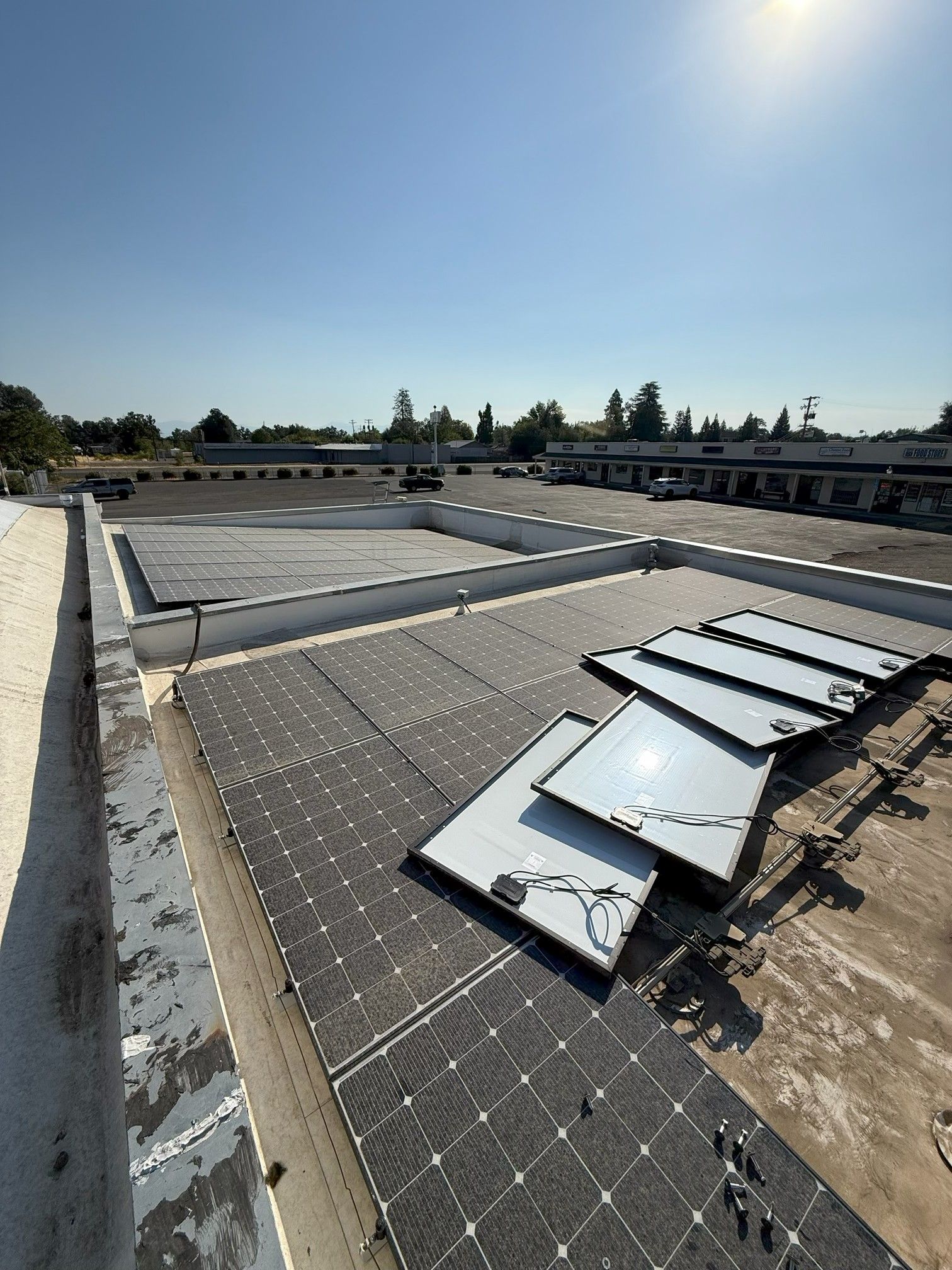 Solar panels installed on a flat rooftop under bright sunlight and clear sky