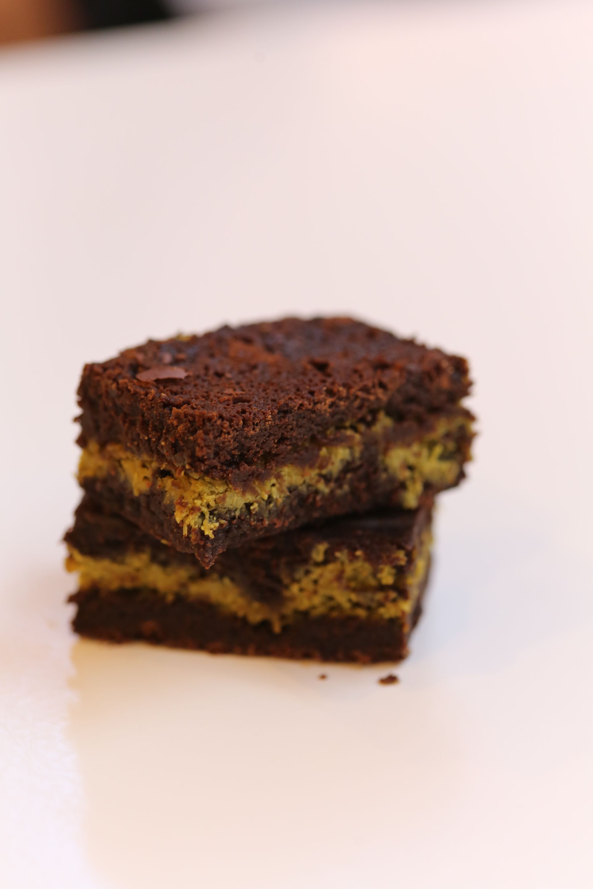 Due quadrati di torta al cioccolato sovrapposti su sfondo bianco