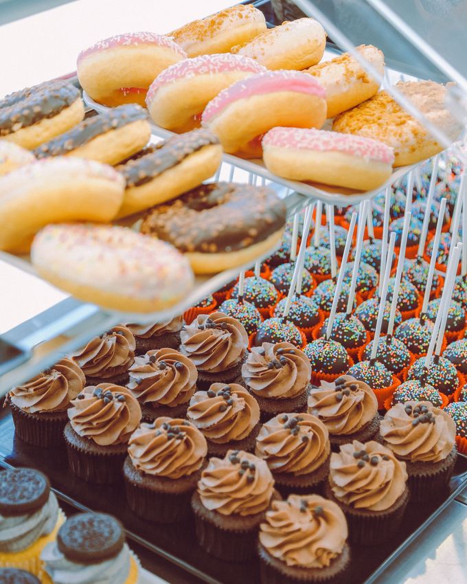 Assortimento di pasticcini e cupcake decorati su un vassoio da buffet di dolci a una festa.