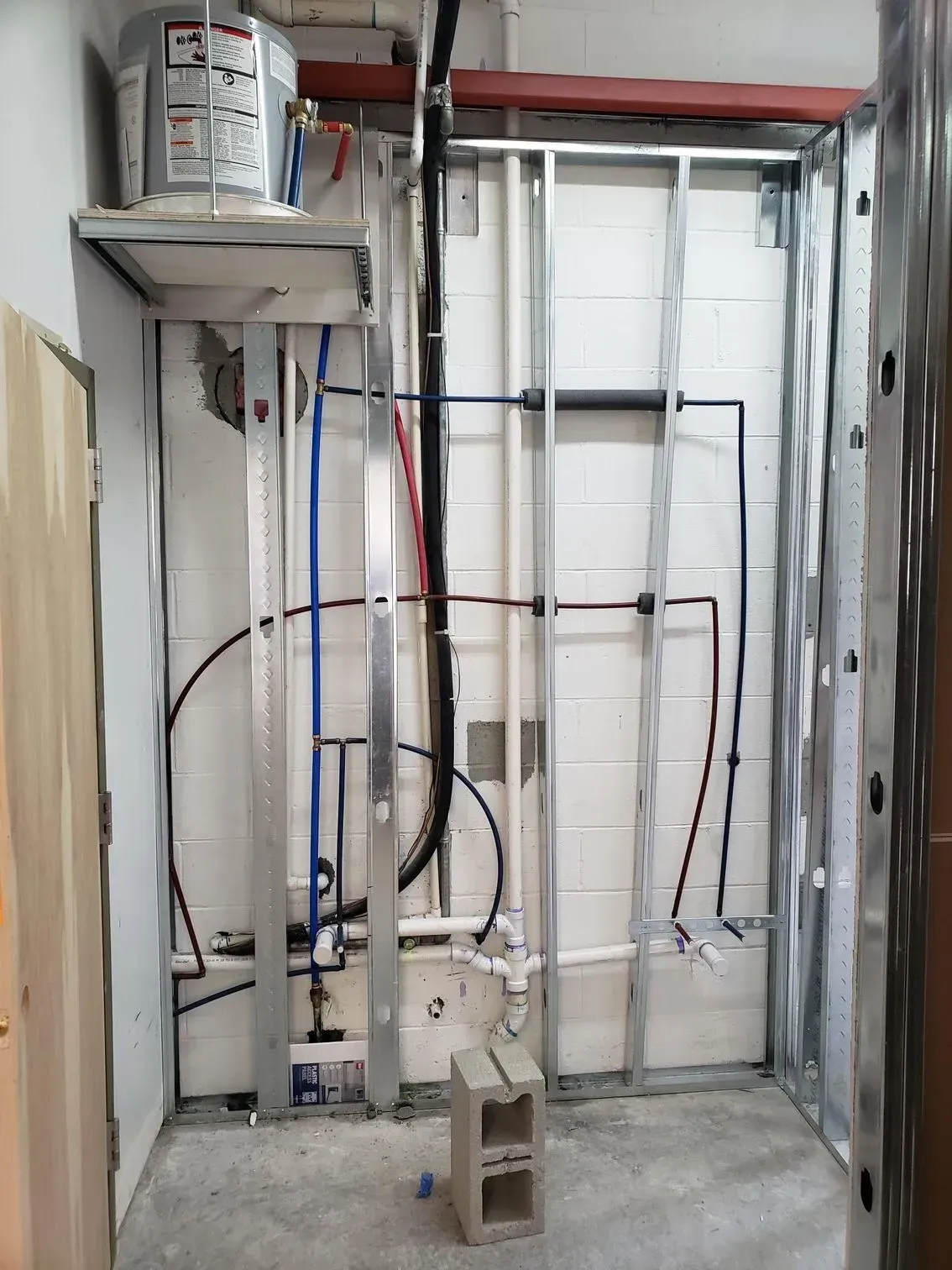 Partially built wall framing with electrical wiring and conduit in a construction site
