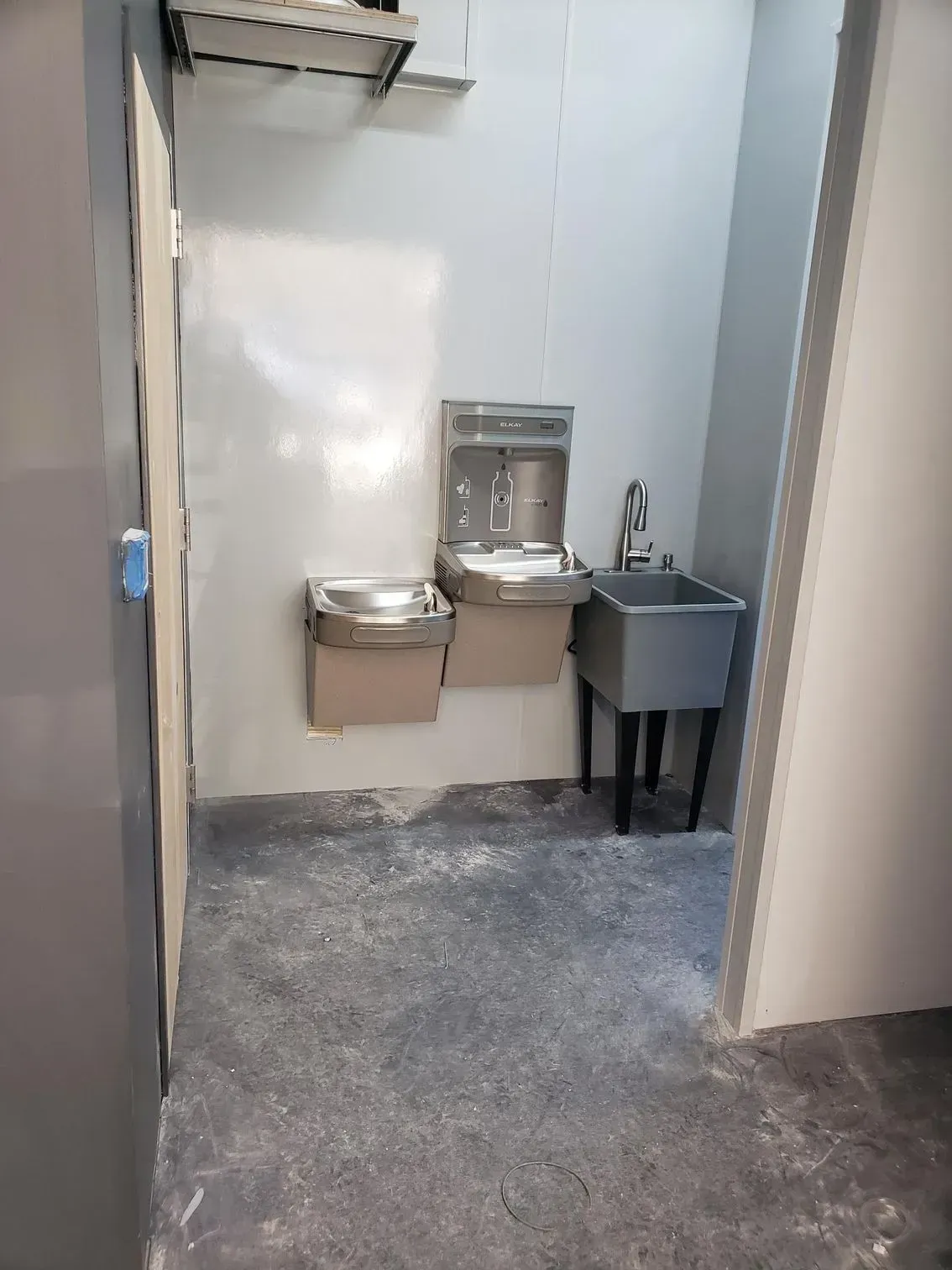 Public restroom with two wall-mounted sinks and a gray handwashing station.