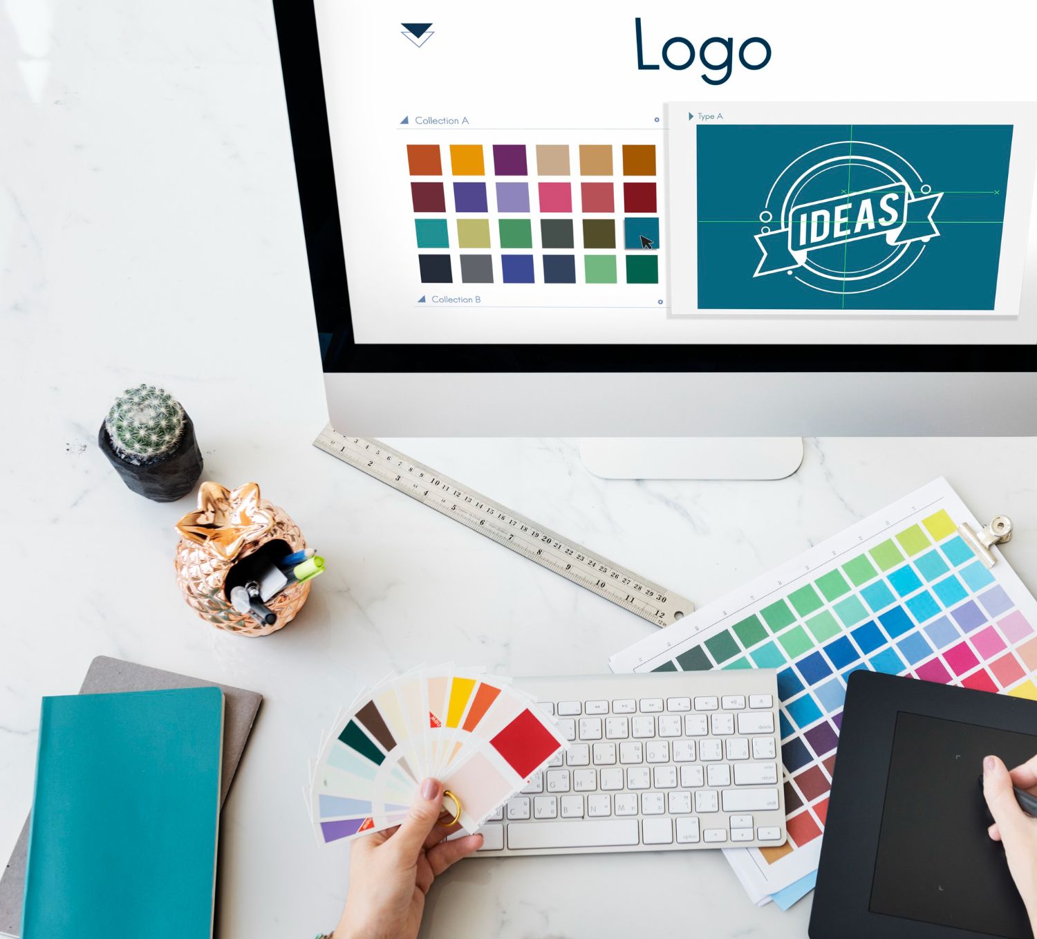 A person holds color swatches at a desk with a computer displaying logo design software and various color palettes.
