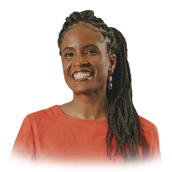 Uma mulher com tranças está sorrindo e vestindo uma camisa vermelha