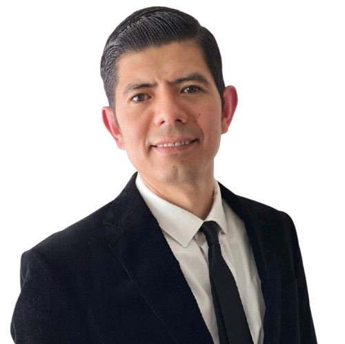 Man in a black suit and tie, smiling at the camera.