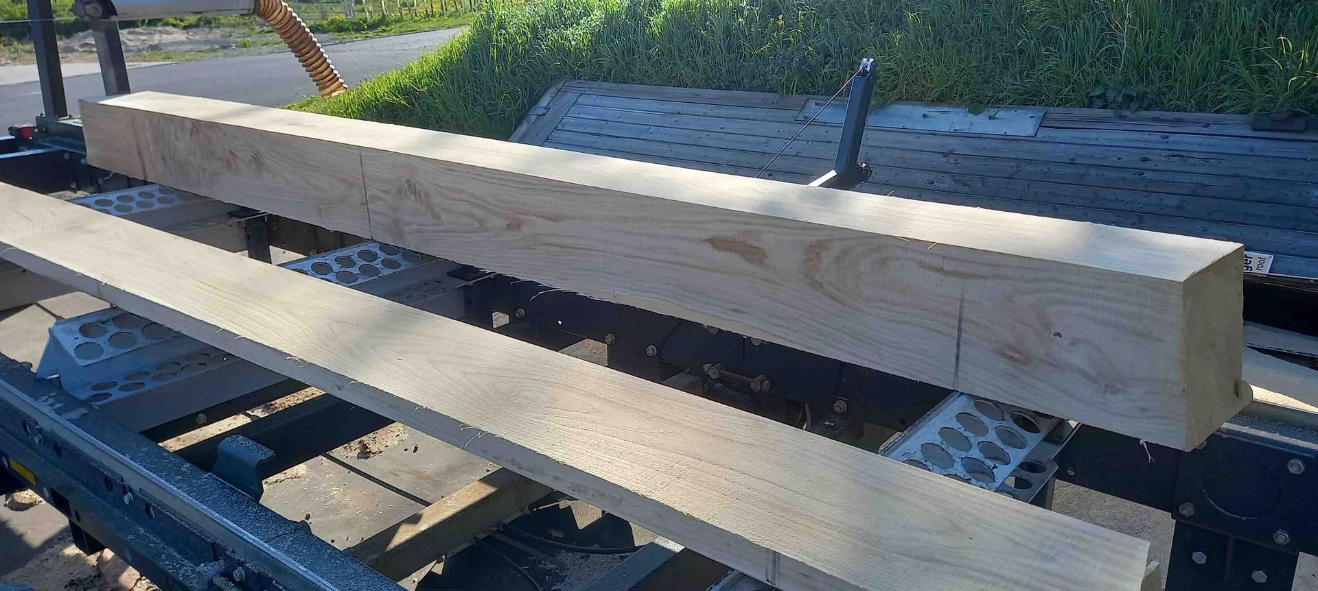 image showing planks and beam cut from an oak trunk on the bandsaw mill