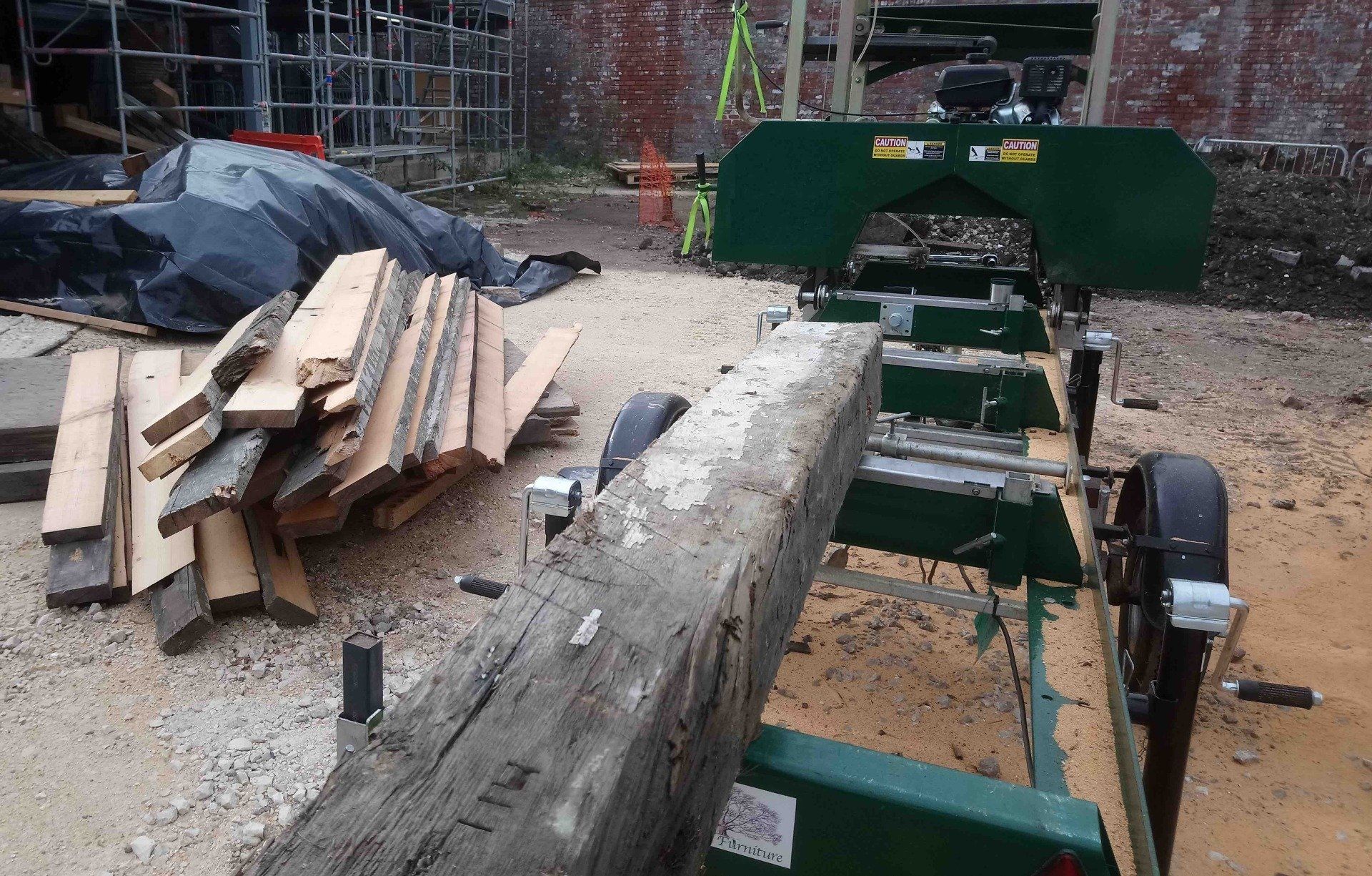 Reclaimed beams from a demolished victorian warehouse at Kelham Island, Sheffield being milled into boards for use around the new housing complex being built on site 