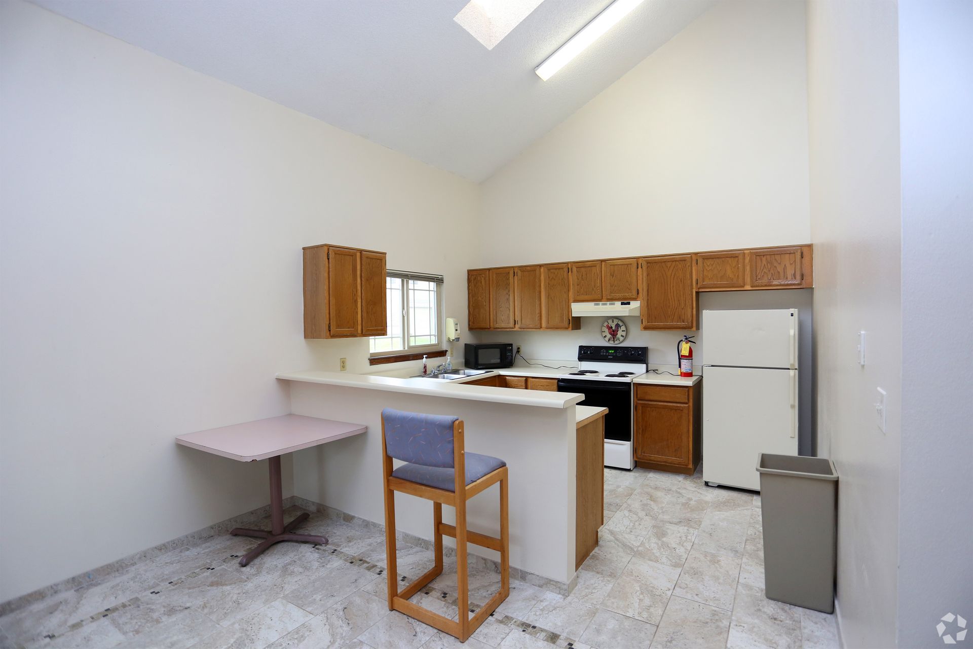 A kitchen with a table and chairs and a refrigerator