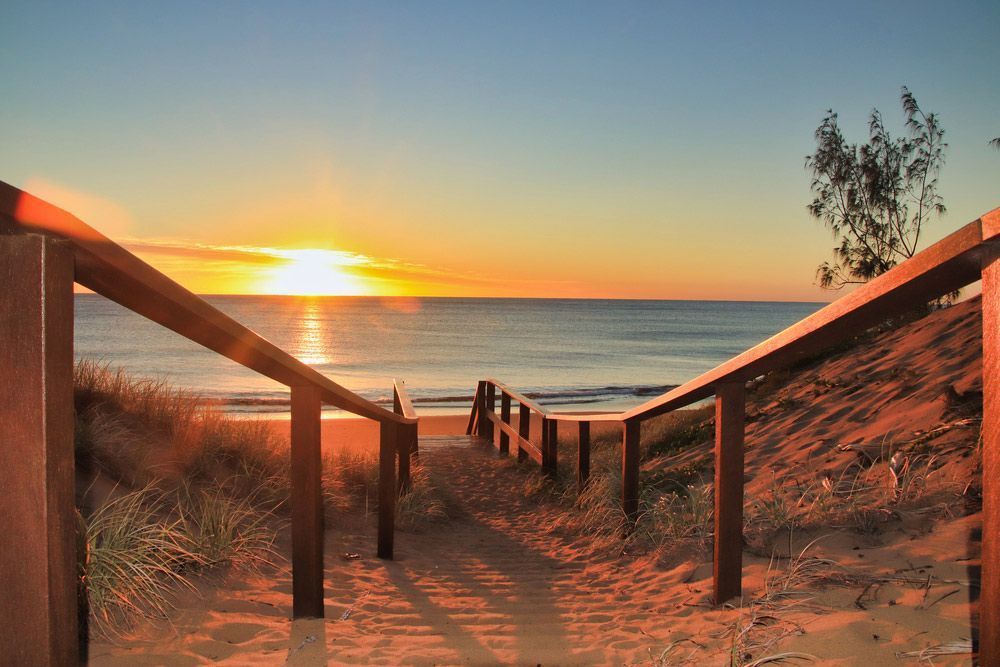A Wooden Staircase Leading To The Beach At Sunset — ADK Coatings In Agnes Water, QLD