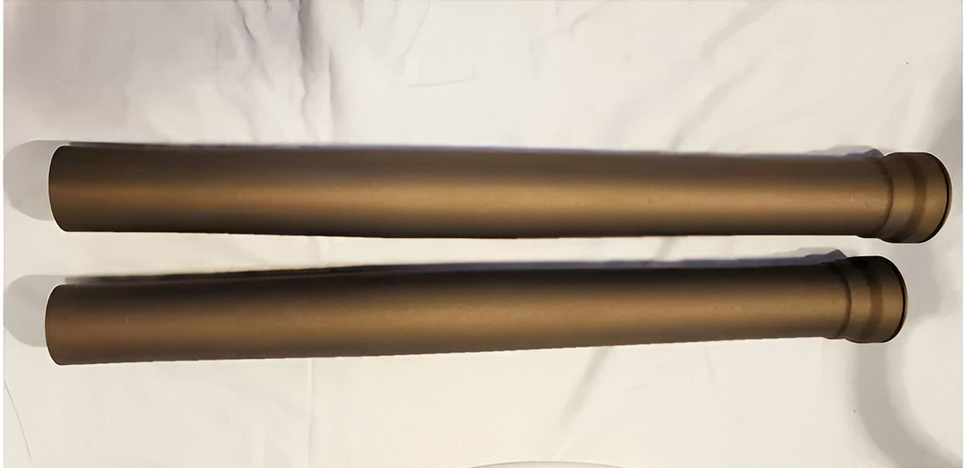 Two Metal Pipes Are Sitting Next To Each Other On A White Surface — ADK Coatings In Agnes Water, QLD