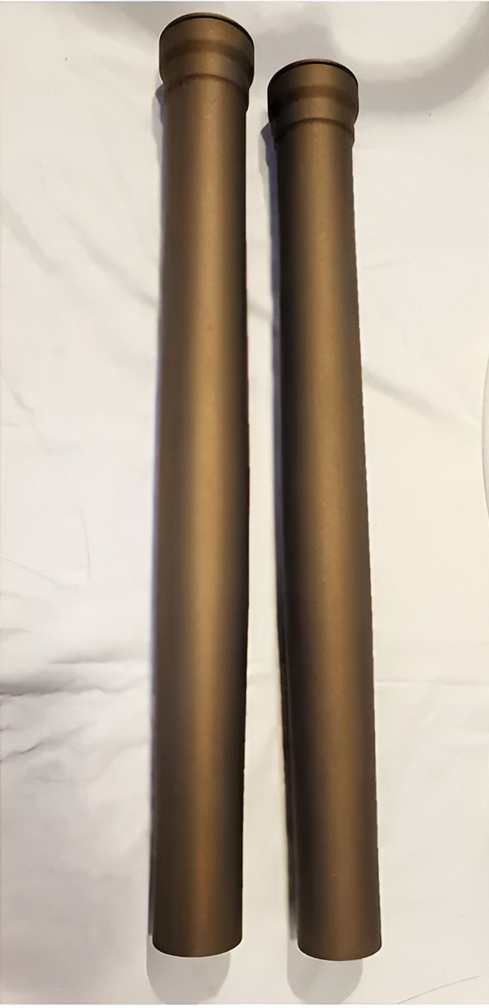 Two Brown Pipes Are Sitting On A White Surface — ADK Coatings In Boyne Island, QLD