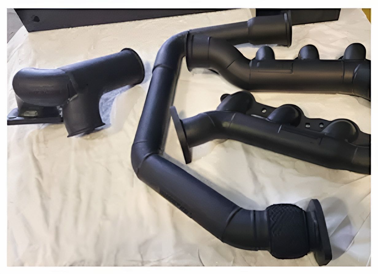A Bunch Of Black Pipes Are Sitting On Top Of A Bed — ADK Coatings In Toolooa, QLD
