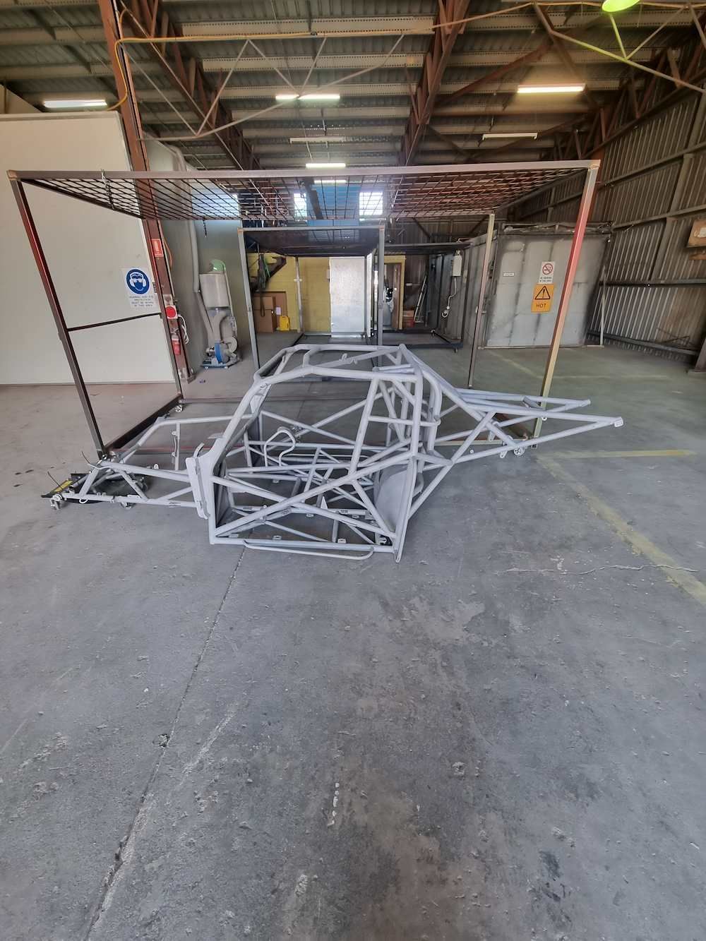 A Large Metal Structure Is Sitting In A Warehouse — ADK Coatings In Tannum Sands, QLD