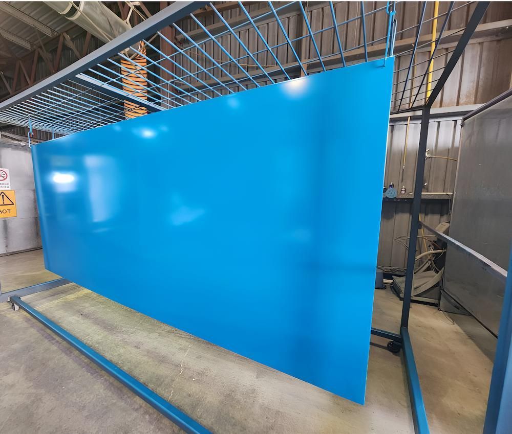 A Large Blue Piece Of Metal Is Sitting On Top Of A Metal Rack — ADK Coatings In Toolooa, QLD