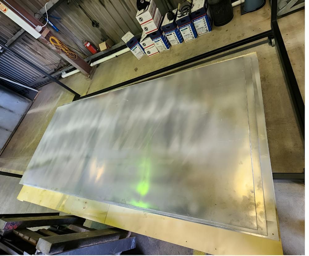 A Large White Board Is Hanging From A Metal Rack In A Warehouse — ADK Coatings In Toolooa, QLD