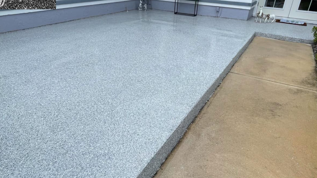 Gray speckled epoxy floor next to a brown concrete walkway.