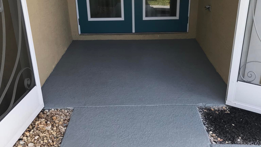 Entryway with grey painted concrete, blue door, and open white doors.