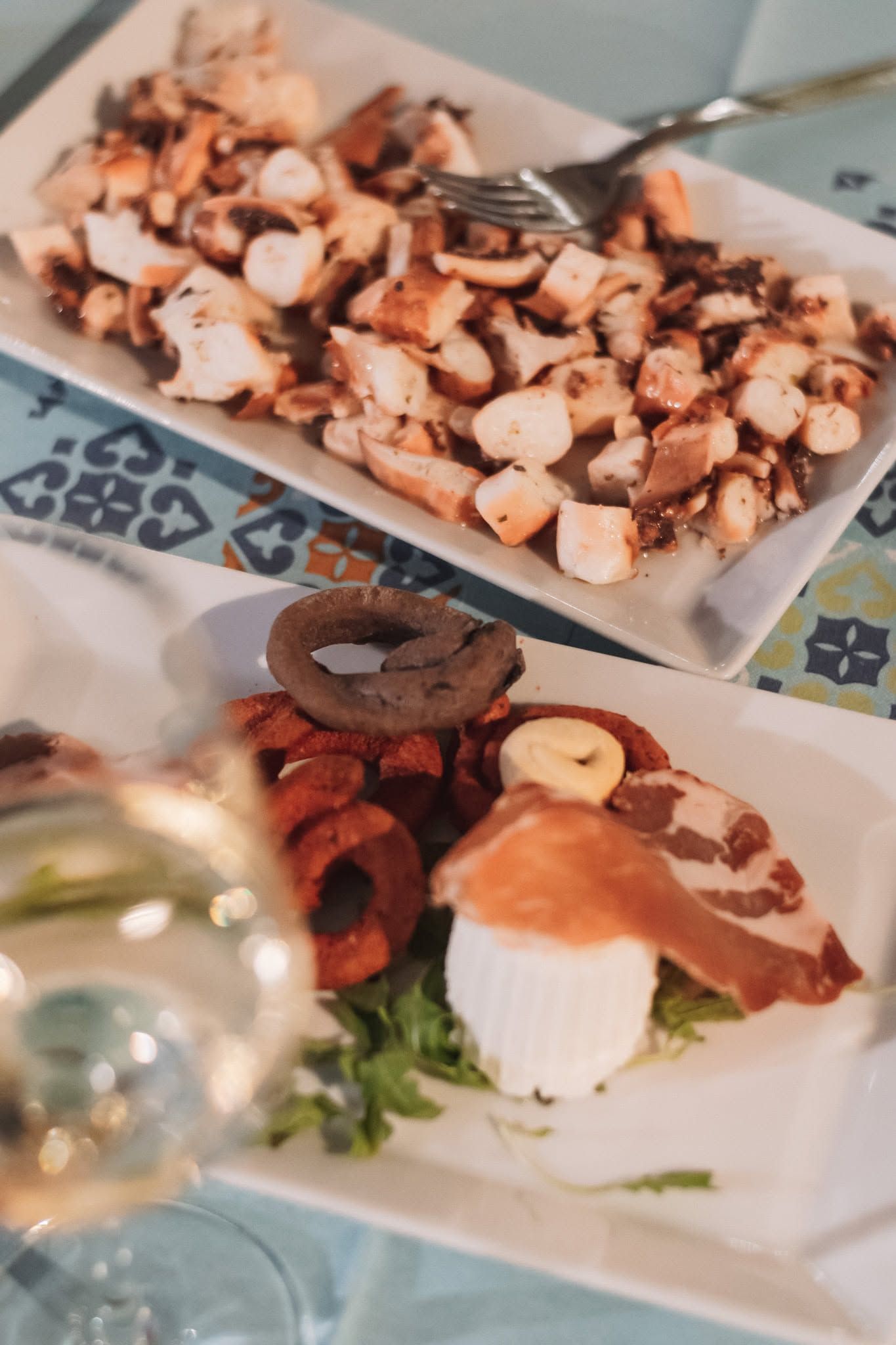 Piatto di polpo a fette e antipasto di mare impiattato, con guarnizioni, su un tavolo da buffet