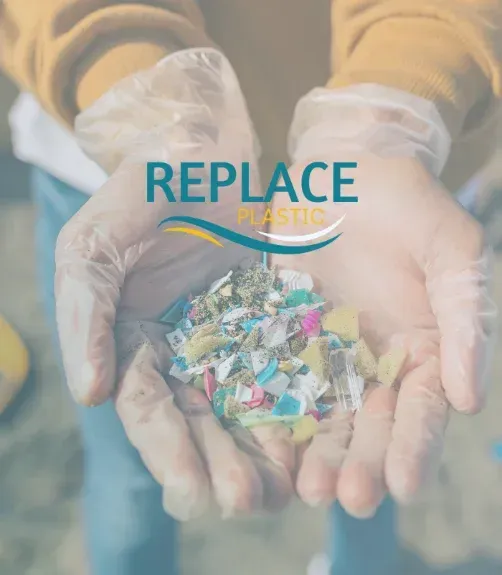 A person wearing gloves is holding a pile of plastic in their hands.