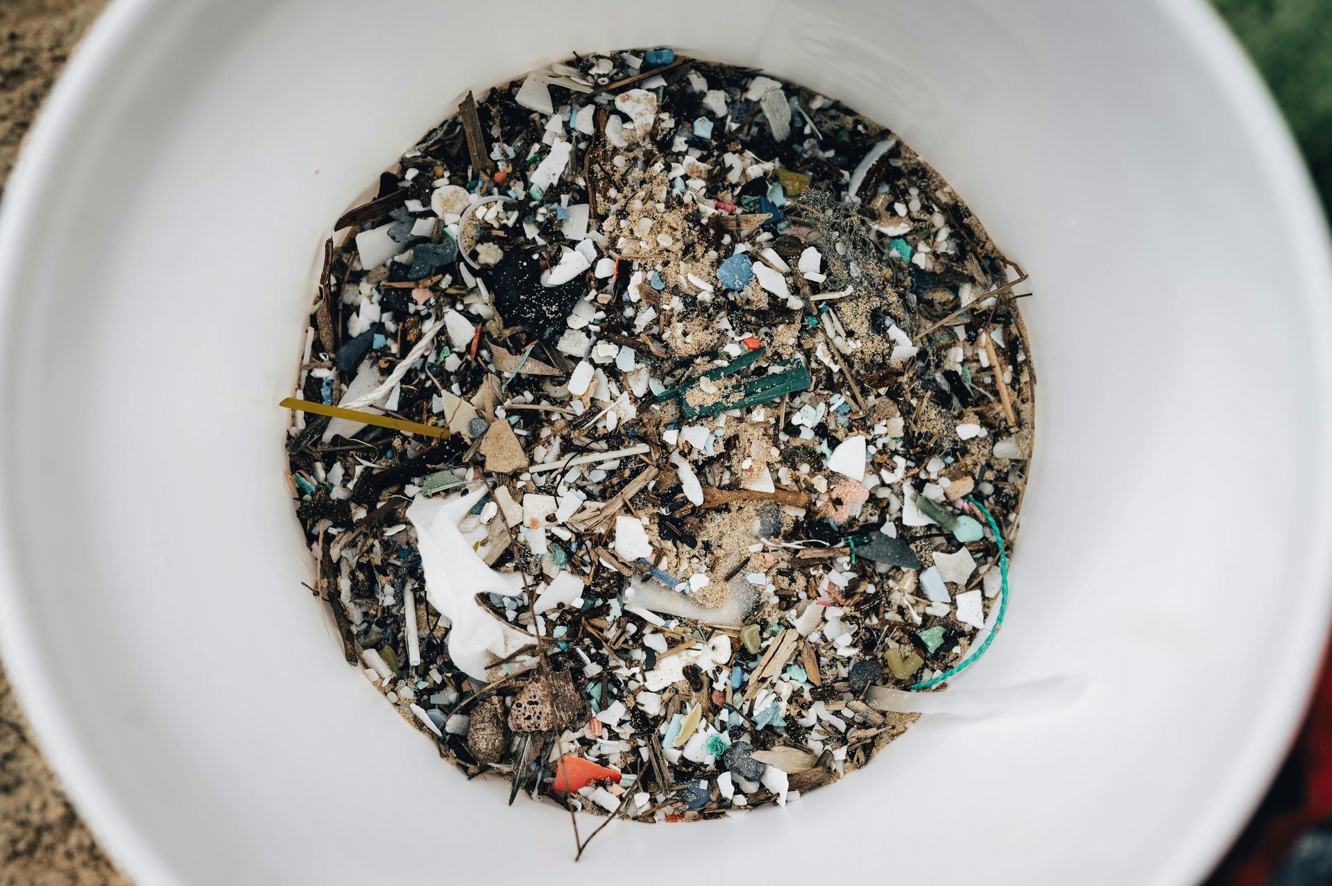 A white bowl filled with a lot of different types of trash