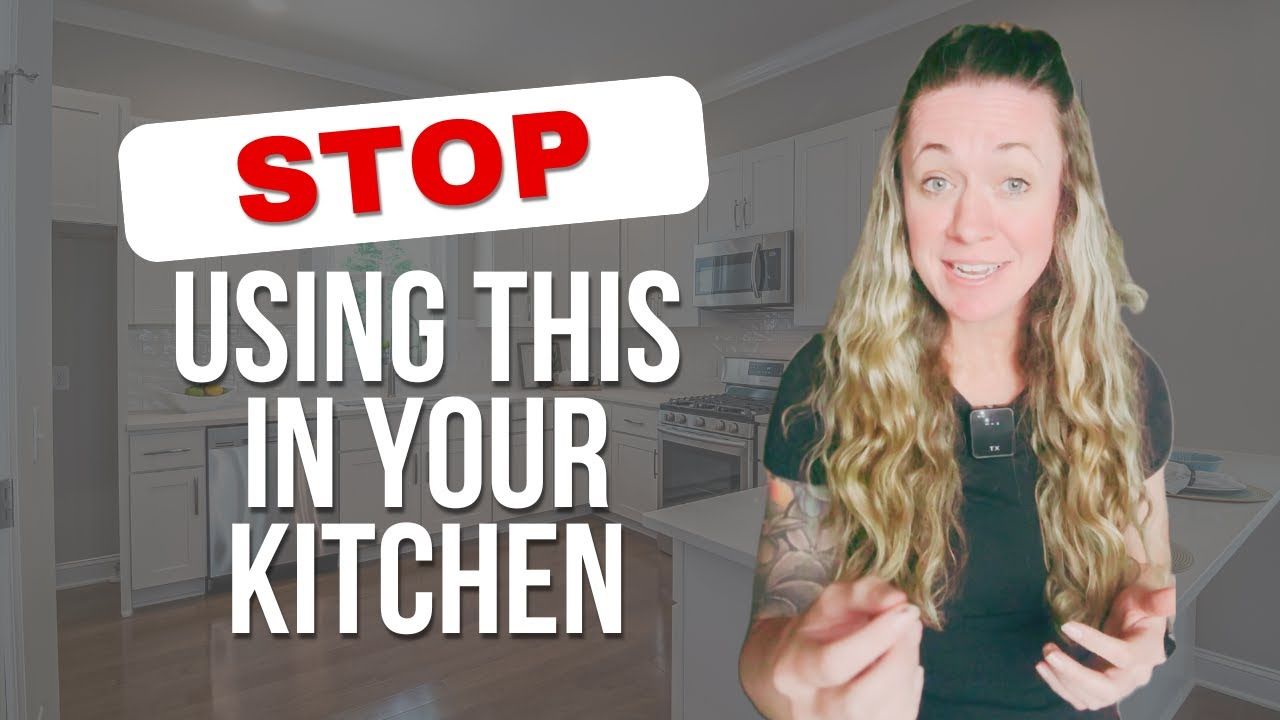 A woman is standing in a kitchen with a sign that says stop using this in your kitchen.