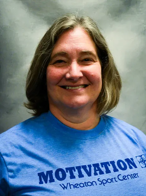 Smiling woman in a blue MOTIVATION T-shirt against a gray studio background