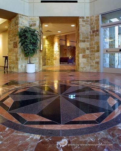 Lobby entrance with stone columns and a large circular mosaic floor design