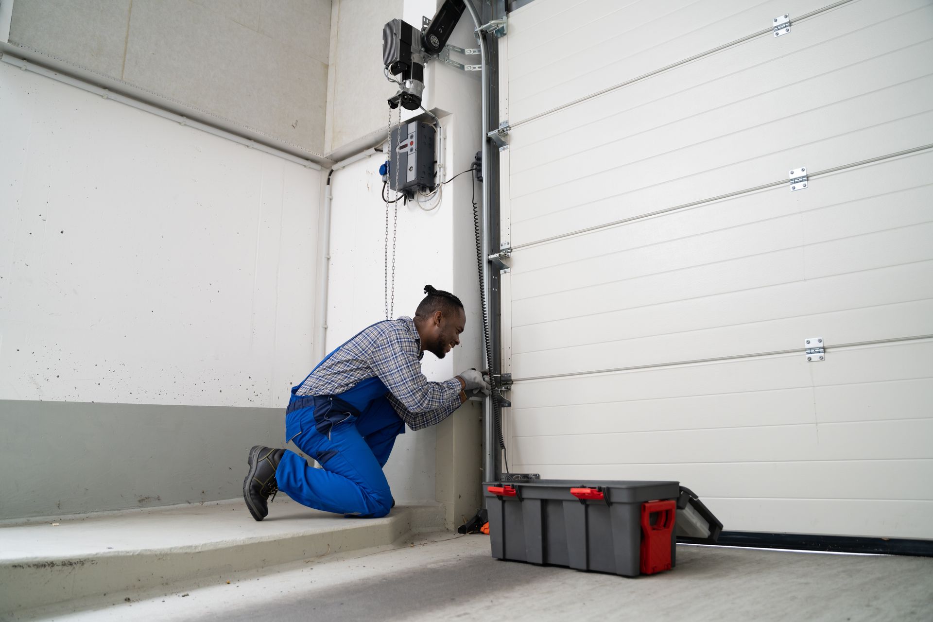 Technician replacing a broken torsion spring on a sectional door during a garage door repair visit.