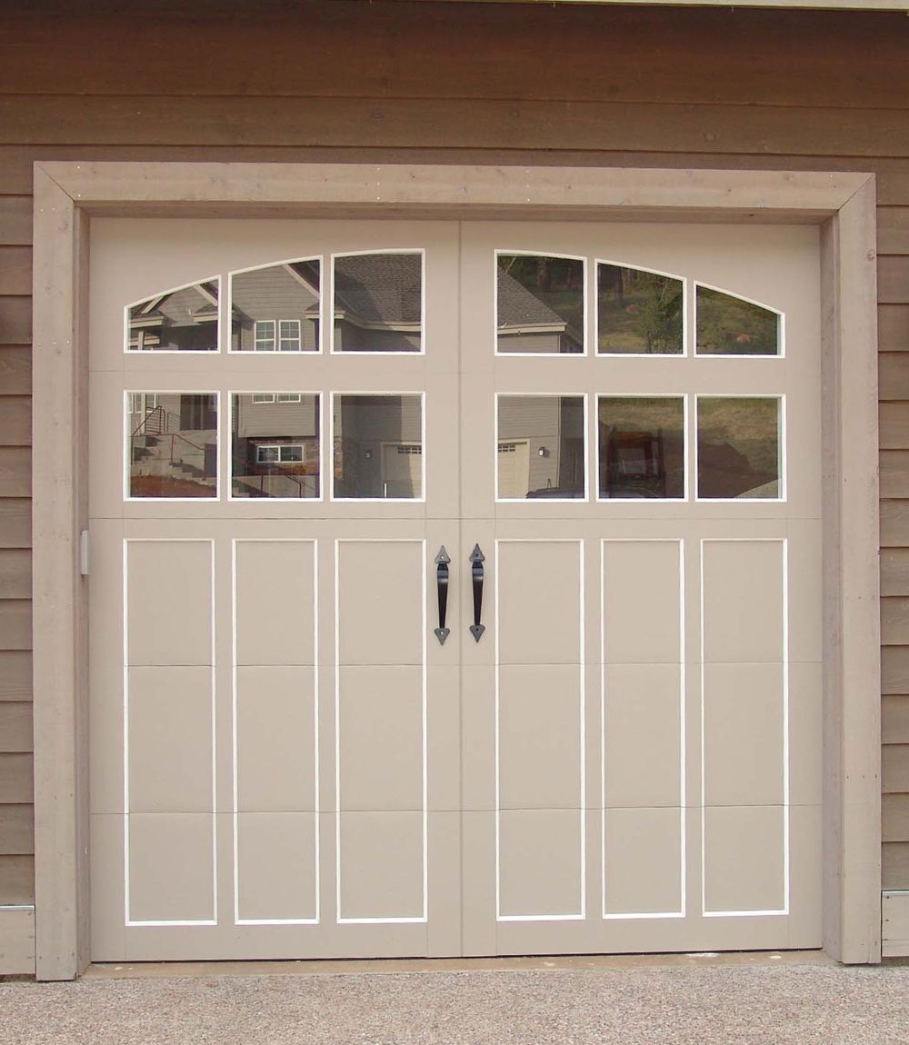 White garage door with small window panes in a beige building exterior.