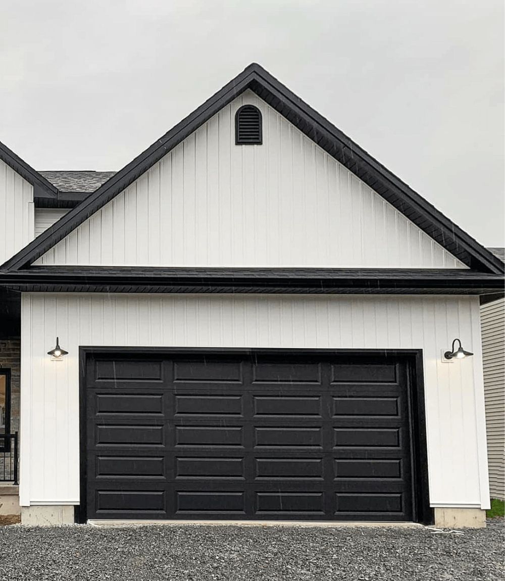 White house facade with black garage door and dark gray gable trim