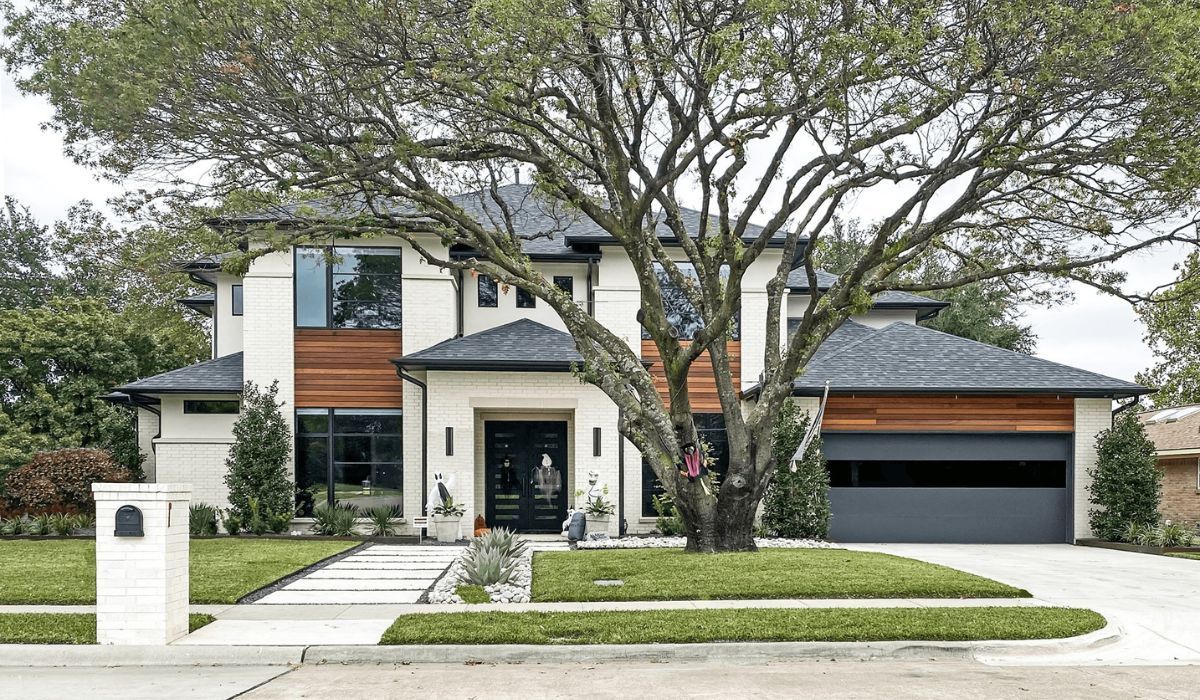 Modern two-story house with large tree, white-and-wood exterior, and a two-car garage