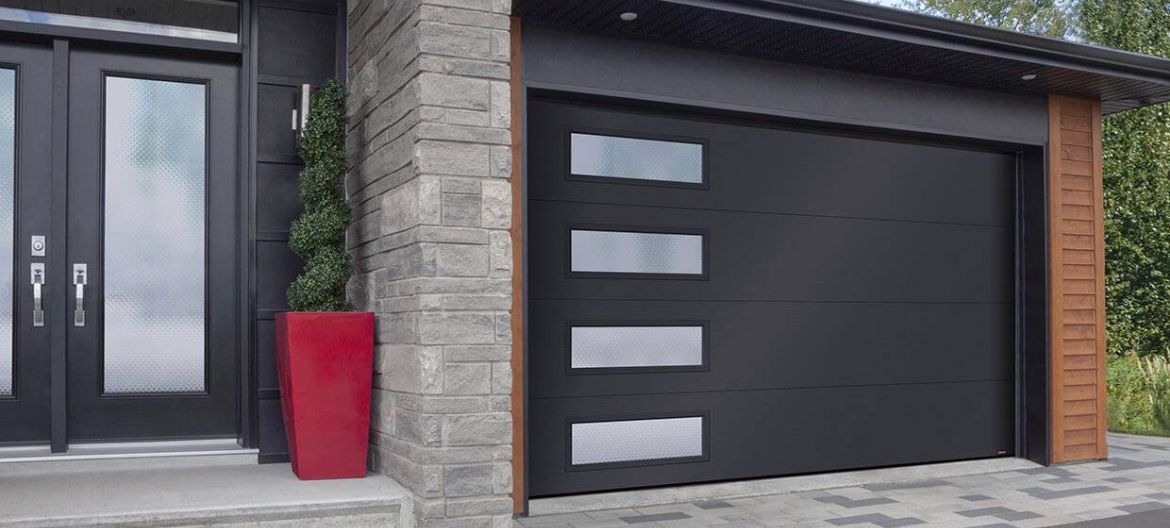 Modern house exterior with black garage door, stone facade, and red planter by the entrance