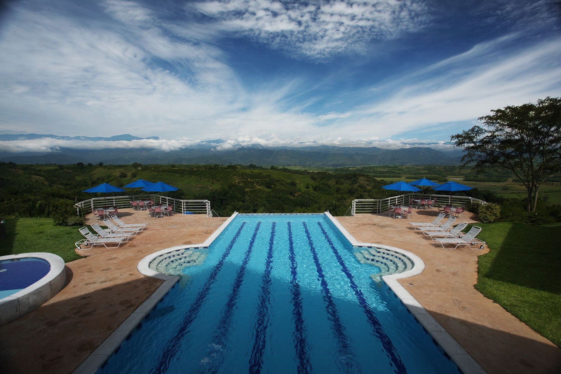 Una gran piscina rodeada de sillas y sombrillas.