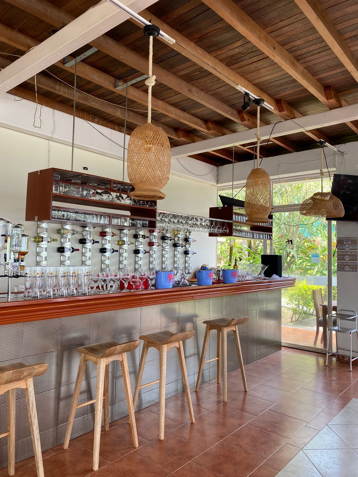 Un restaurante con barra y taburetes y techo de madera.