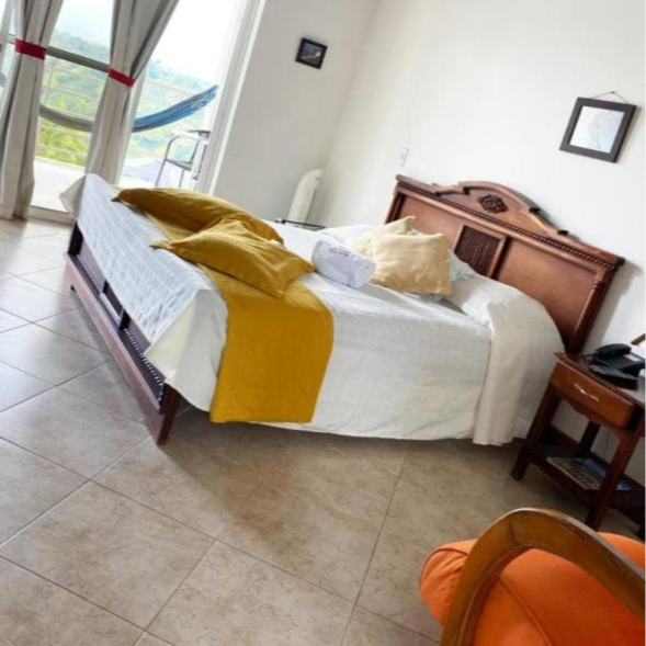 Un dormitorio con una cama grande y una silla.